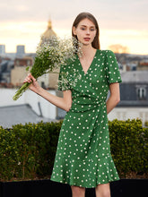 A lady wears a polka dot green midi dress.